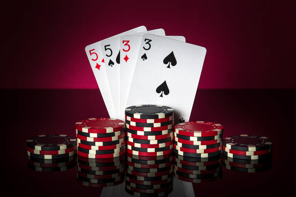 Игра в покер с комбинацией из двух пар. Чипсы и карты на стол. Успешный и wi - Фото, изображение