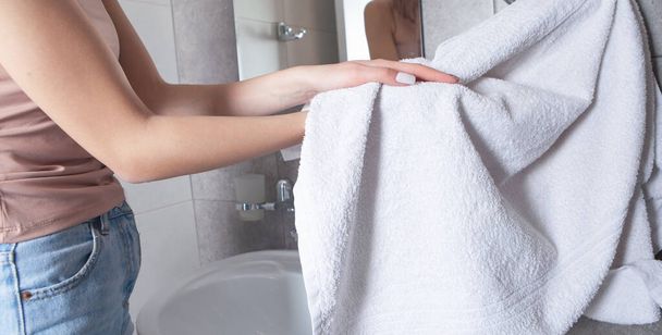 Tuvalette elleri silmek için havlu kullanan bir kadın..  - Fotoğraf, Görsel