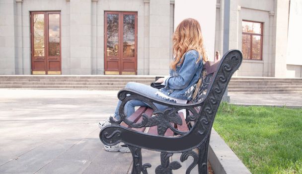 giovane donna seduta sulla panchina in città
. - Foto, immagini