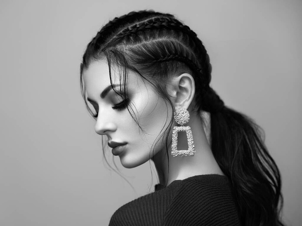 Brunette girl with perfect makeup. Beautiful model woman with curly hairstyle. Care and beauty hair products. Lady with braided hair. Model with jewelry. Black and white photo - Fotografie, Obrázek