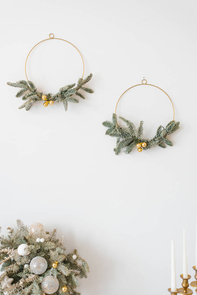 Elegantes coronas de Navidad en la pared blanca en el interior del hogar - Foto, Imagen