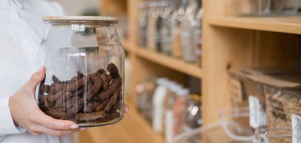 A woman holds croutons in a glass jar. Eco shop without plastic waste. - Foto, Bild