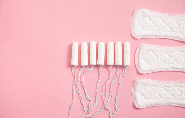 Menstruatiepad en tampons op een roze achtergrond. - Foto, afbeelding