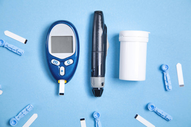 Глюкометр з тестовими смугами та іншими об'єктами. Прилади для вимірювання глюкози в крові
 - Фото, зображення