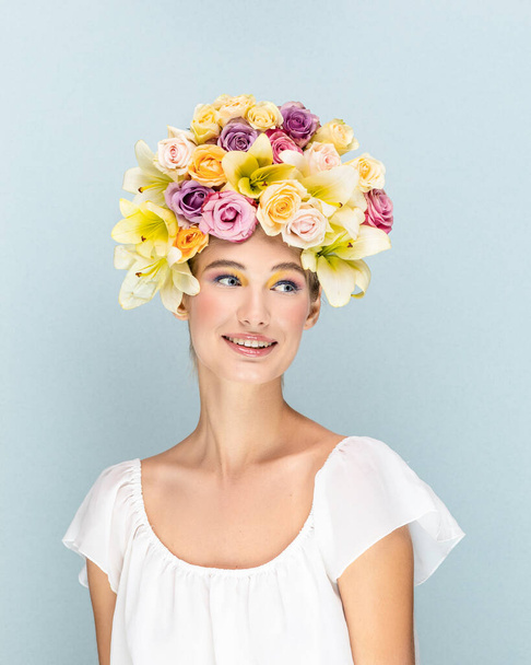 Young girl gently smiles and looks into the camera lens with flowers in the head  - 写真・画像