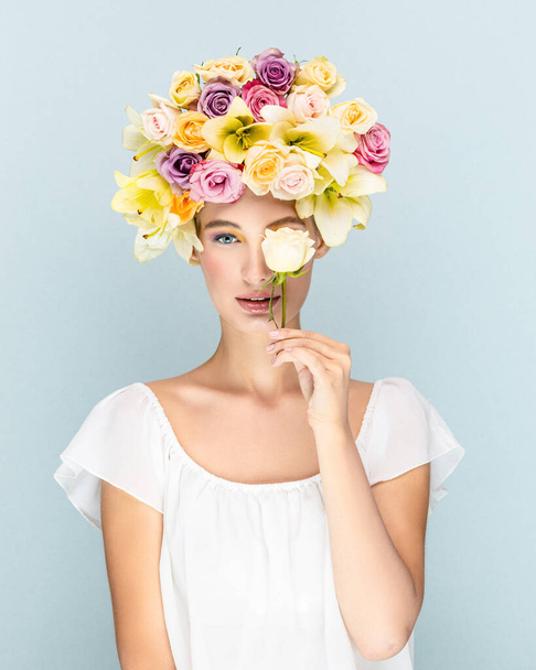 Mysterious young girl looks into the camera lens with flowers in the head  - Foto, Imagem
