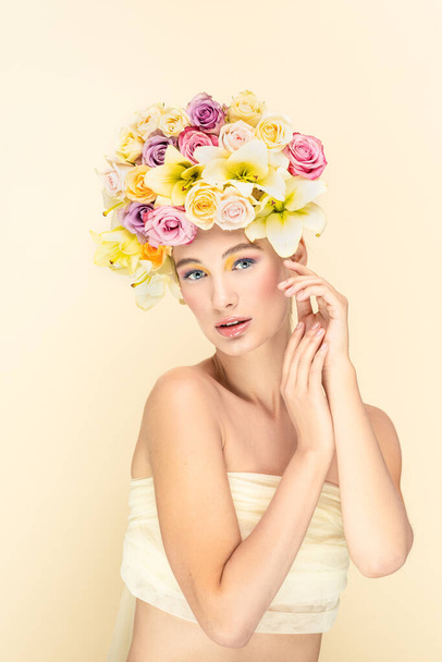 Spring concept, young girl looks into camera lens with flowers in the head  - Foto, imagen