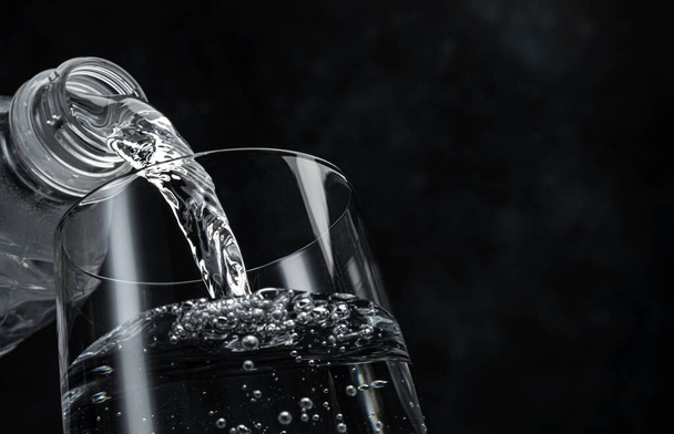 Pouring water on black background  - Foto, Bild
