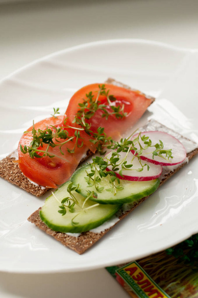 sandwiches with tomatoes, cucumbers and radishes with micro-greenery on bread rolls - 写真・画像