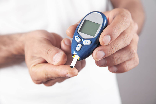 Homme mesurant le taux de glucose à la maison. - Photo, image