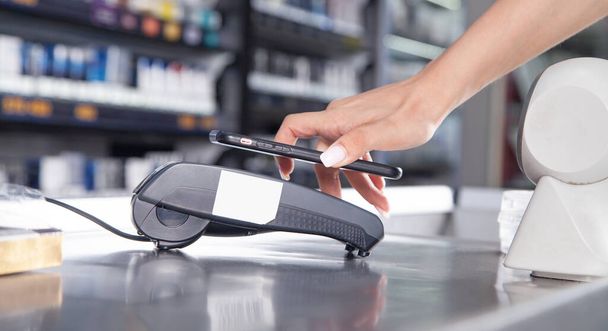Customer paying for purchases contactless with smartphone. - Photo, Image