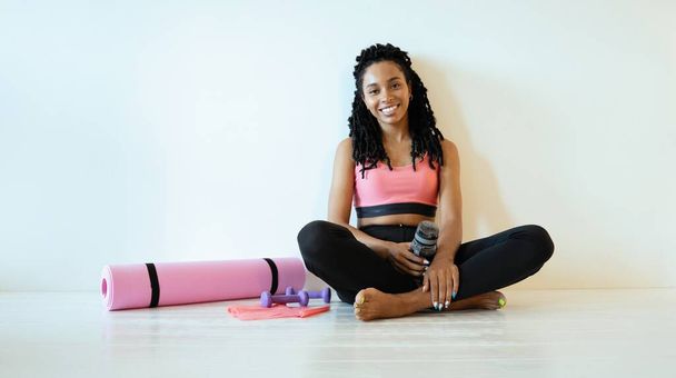 Satisfied young black woman sitting and relaxing after her work out - Zdjęcie, obraz