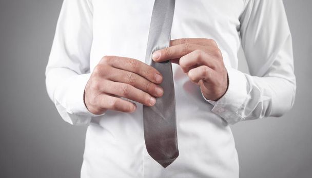 Üzletember megjavítja a nyakkendőjét. Divat, Életmód - Fotó, kép