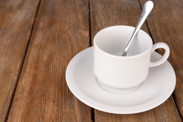 Tazza vuota con cucchiaino da tè su sfondo di legno
 - Foto, immagini