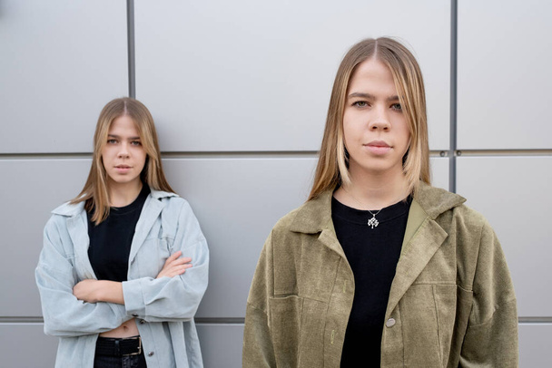 One of blond twin sisters standing in front of camera - Photo, Image