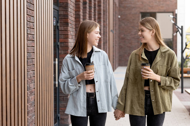 Милі дівчата-підлітки з напоями гуляють по місту
 - Фото, зображення
