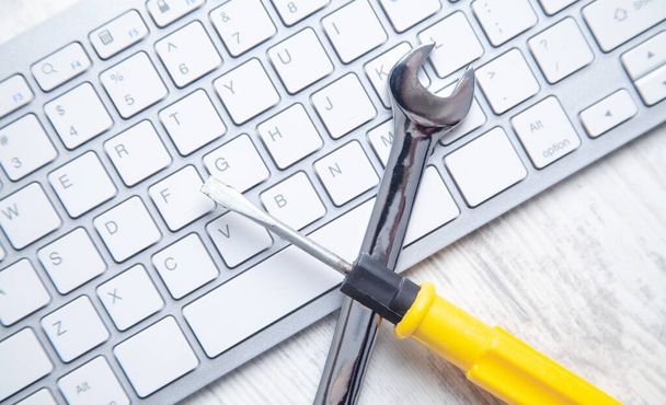 Wrench and screwdriver on the computer keyboard. IT Service. Support - Foto, Imagem