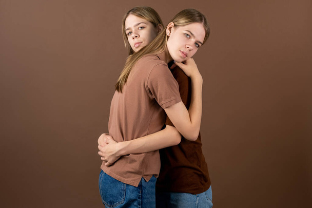 Lindos gemelos adolescentes que se dan un abrazo frente a la cámara - Foto, imagen