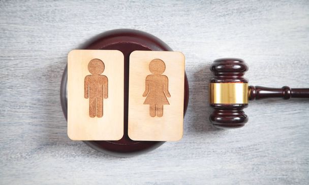 離婚の概念。男性と女性の木製のシンボルと裁判官の砂利 - 写真・画像