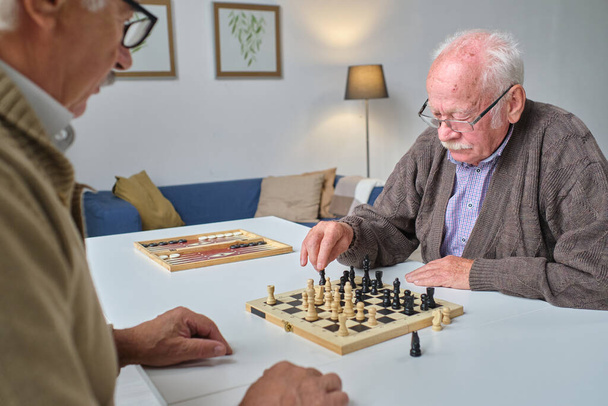 Senior people playing chess together - Фото, изображение