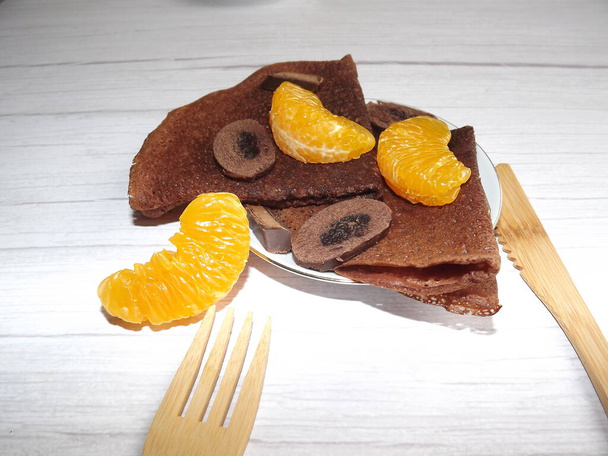 desszert csokoládés palacsintával, csokoládé mandarin szeletekkel - Fotó, kép