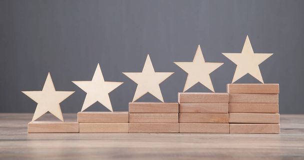 Wooden 5 stars on wooden block. Increase rating - Foto, afbeelding