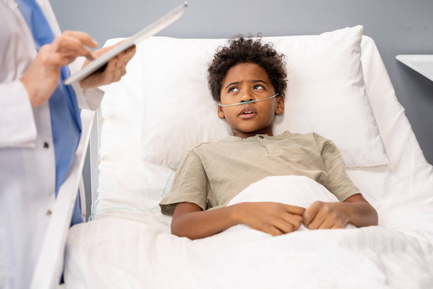 Boy lying in bed in the ward - Фото, зображення