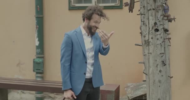 young sexy businessman waving, presenting us a wooden pillar and giving a thumbs up - Footage, Video