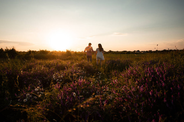 Lovely couple walking in the summer field - 写真・画像