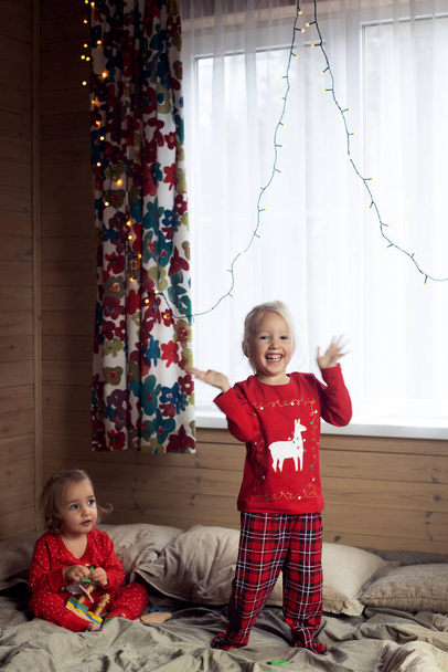 Due bambini ragazze sorelle divertirsi a letto mattina di Natale - Foto, immagini