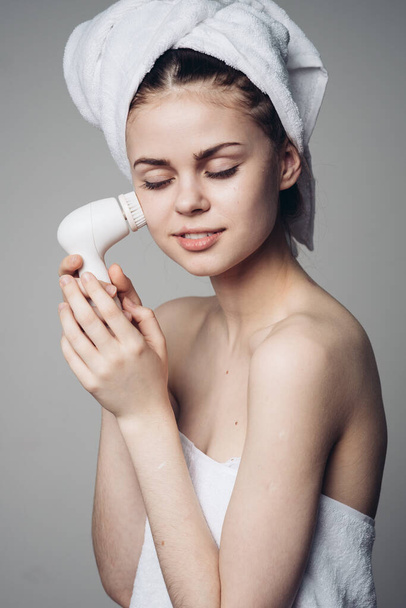 woman with towel on head facial massager skin care hygiene - Foto, Imagem