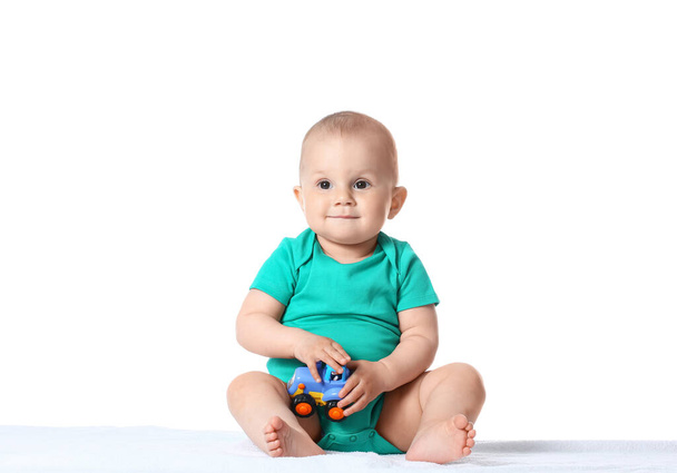 Cute little baby boy playing with toy car on white background - Fotografie, Obrázek