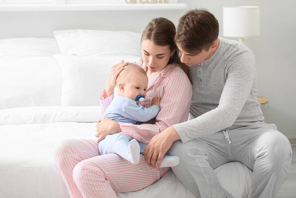 Young parents with little baby boy in bedroom - Photo, image