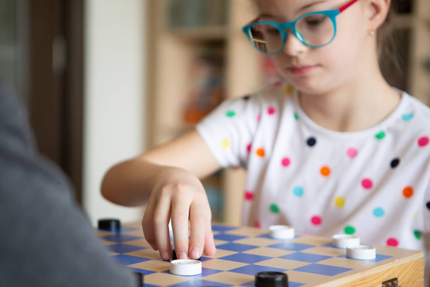 Girl with Down Syndrome playing checkers - Photo, image
