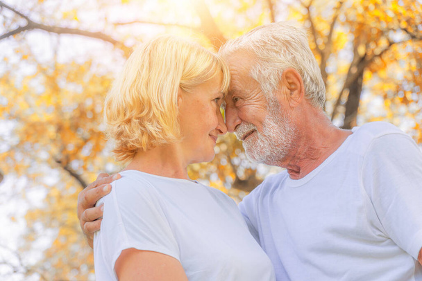 caucasian senior couple happy together with romantic moment outdoor in park in autumn - Foto, afbeelding