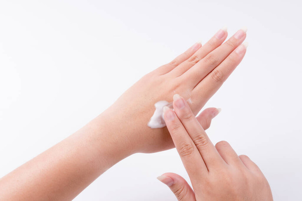 Close up donna applica crema sulle mani su sfondo bianco - Foto, immagini