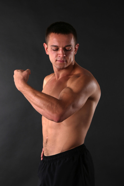 Handsome muscle young man on dark background - Foto, imagen
