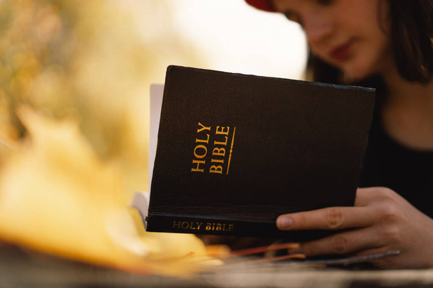 Christian teen girl tient la bible dans ses mains. Lire la Sainte Bible. Concept de foi - Photo, image