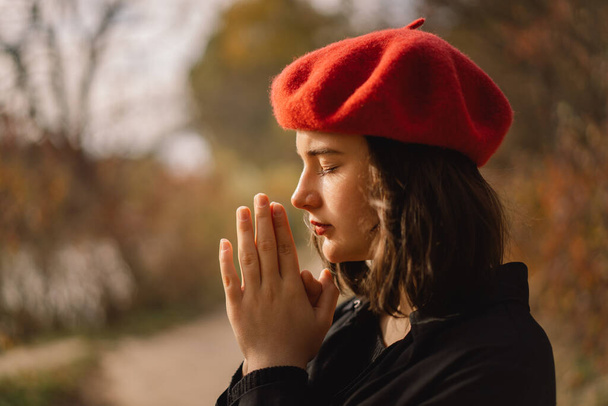 Девочка-подросток закрыла глаза и молилась. Руки сложены в молитвенной концепции веры, религии. - Фото, изображение