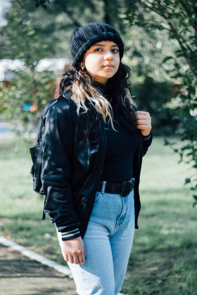 Споглядальна латинська дівчина-підліток коледжу, що йде в парку
 - Фото, зображення