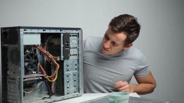 Junger Mann öffnet einen sehr staubigen Computer - Filmmaterial, Video