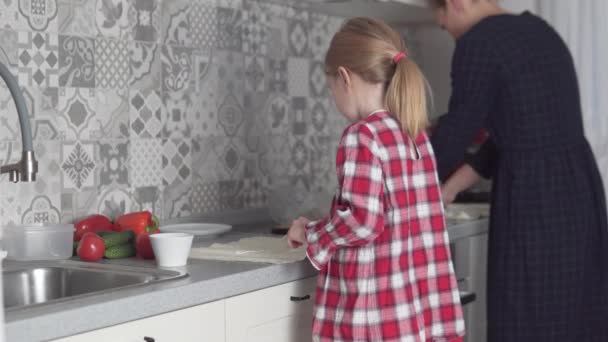 Äiti ja pieni tytär kokki yhdessä keittiössä rulla lavash vihanneksia - Materiaali, video