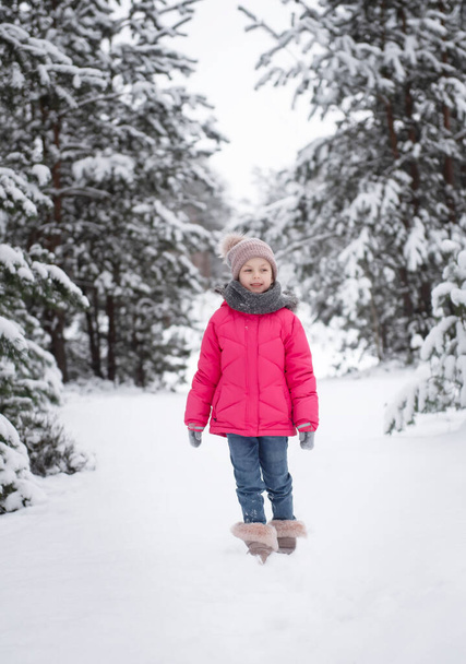 Ребенок зимой. Маленькая девочка играет зимой на улице. Прекрасный зимний детский портрет. Счастливый ребенок, зимние развлечения на свежем воздухе. - Фото, изображение
