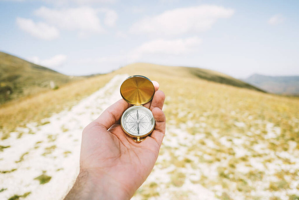Travel concept. Vintage compass in hands in the mountains. - Photo, Image