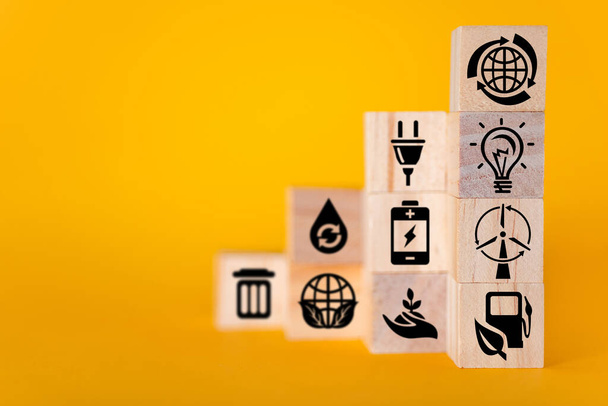 Concepto ecológico con iconos sobre cubos de madera, fondo amarillo. El concepto de energía limpia para todo el mundo. - Foto, imagen