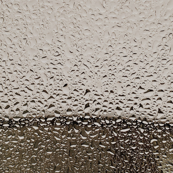 Σταγόνες βροχής και πιτσιλιές πίσω από το γυαλί. Ουδέτερο βροχερό μοτίβο καιρού - Φωτογραφία, εικόνα