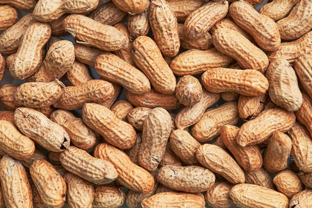 Gesunde geröstete ungeschälte Erdnüsse. Konsistenz brauner Nüsse - Foto, Bild