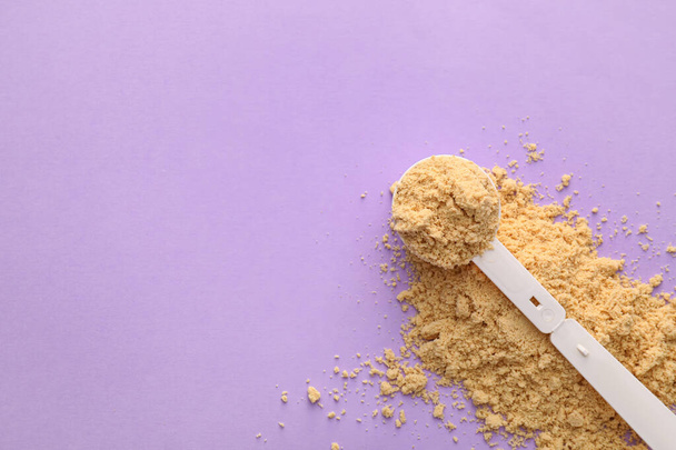Measuring scoop with protein powder on color background - Photo, image