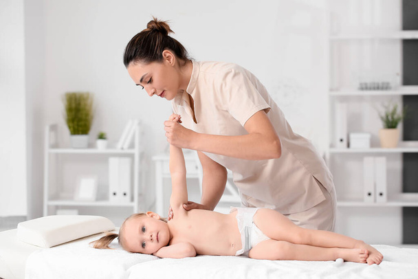 Massage therapist working with baby in medical center - Foto, afbeelding