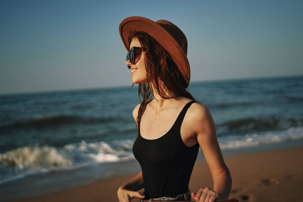 pretty woman in hat walking on the beach ocean travel - Фото, изображение